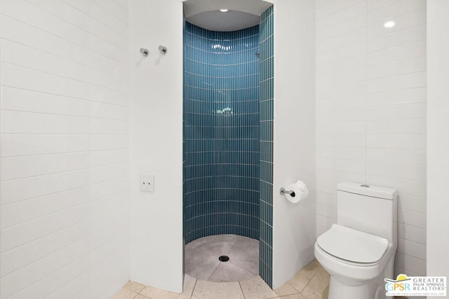 bathroom featuring toilet, a shower, and tile patterned floors