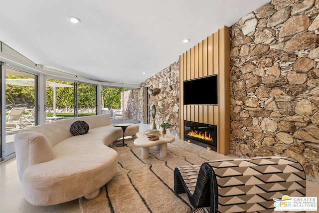 living room with a wall of windows and a fireplace