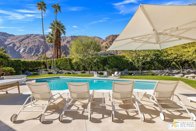 view of pool with a mountain view and a patio