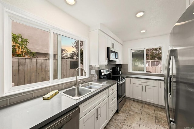 kitchen with sink, white cabinetry, appliances with stainless steel finishes, and tasteful backsplash