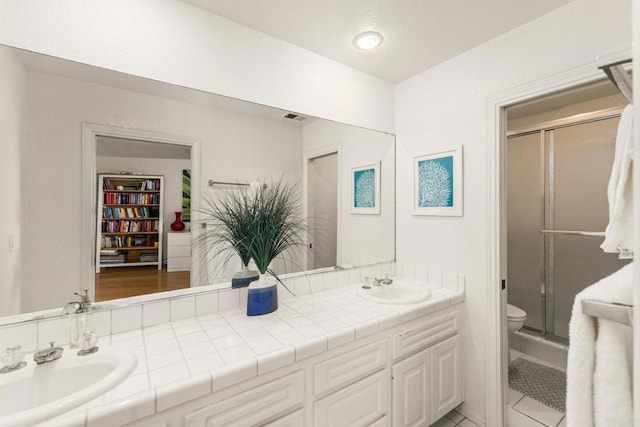 bathroom featuring vanity, toilet, tile patterned flooring, and walk in shower