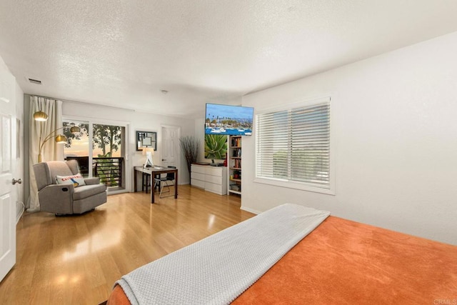 bedroom with a textured ceiling and wood-type flooring