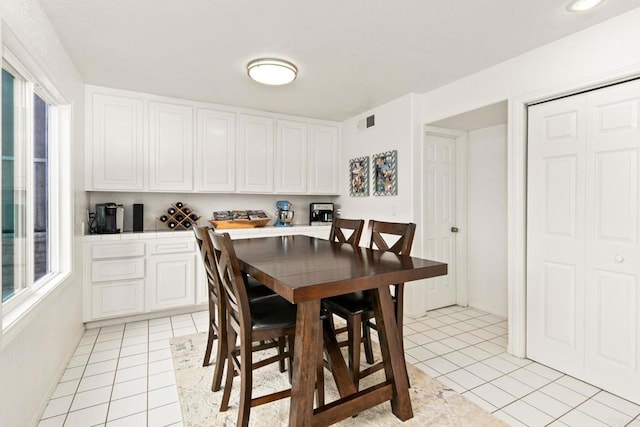 tiled dining room featuring a healthy amount of sunlight