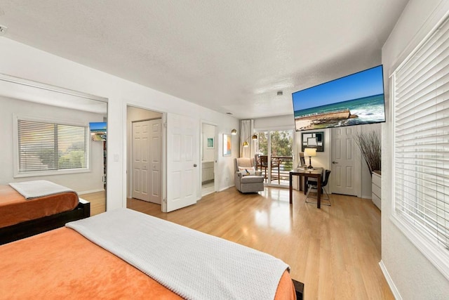 bedroom with light wood-type flooring and a textured ceiling