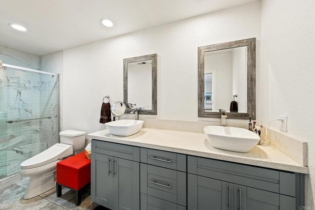 bathroom featuring toilet, vanity, and a shower with door