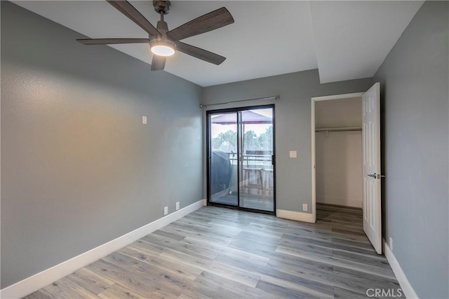 unfurnished bedroom featuring ceiling fan, access to exterior, a closet, and light wood-type flooring