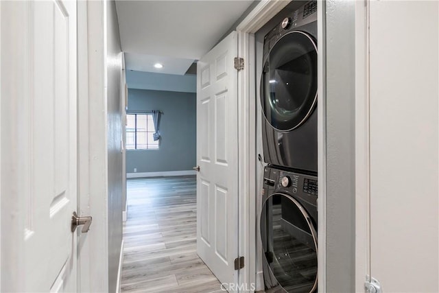 washroom featuring stacked washer and dryer and light wood-type flooring