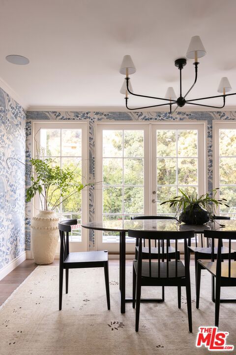 dining area featuring ornamental molding, hardwood / wood-style flooring, and a notable chandelier