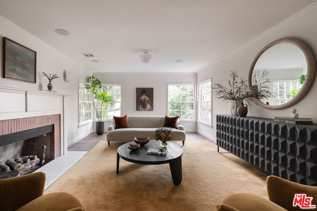 living room with a brick fireplace, wood-type flooring, and ornamental molding