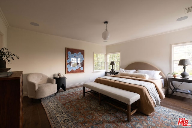 bedroom with dark hardwood / wood-style flooring and crown molding