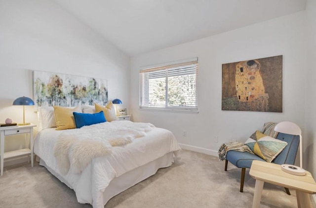 bedroom featuring lofted ceiling and light carpet