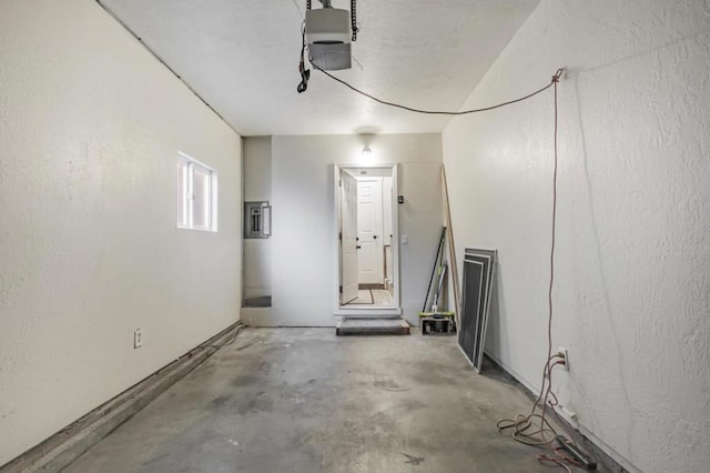 garage with a garage door opener and electric panel