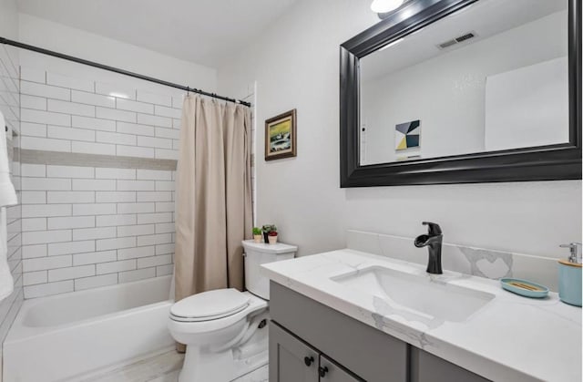 full bathroom with vanity, shower / tub combo with curtain, and toilet