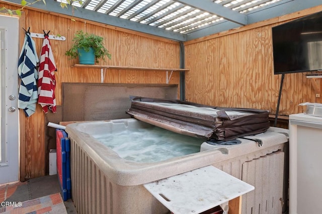 exterior space with a hot tub and wood walls