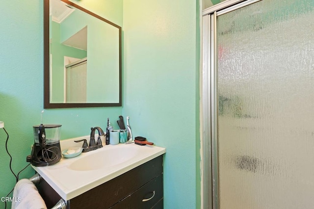 bathroom with ornamental molding, a shower with shower door, and vanity