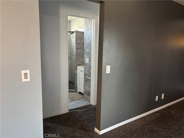 hallway featuring dark colored carpet