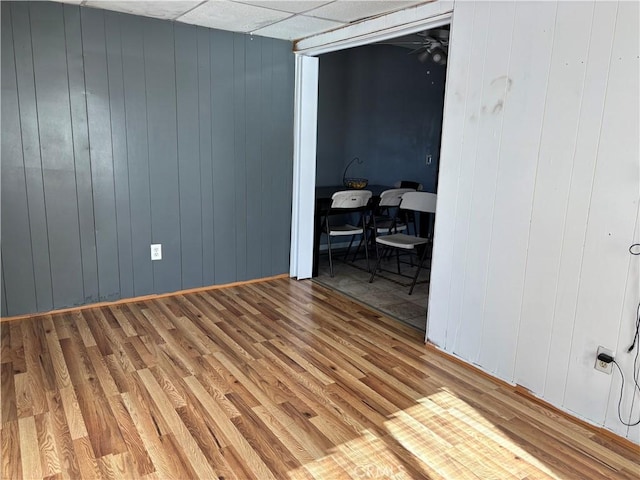 empty room with hardwood / wood-style flooring and wooden walls