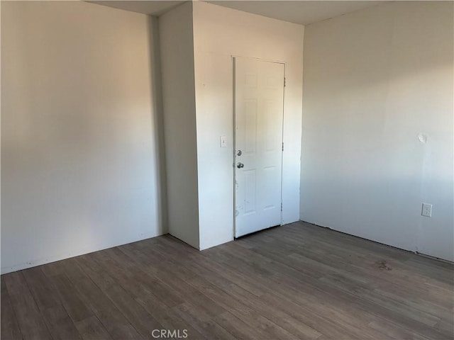 unfurnished bedroom featuring a closet and dark hardwood / wood-style floors