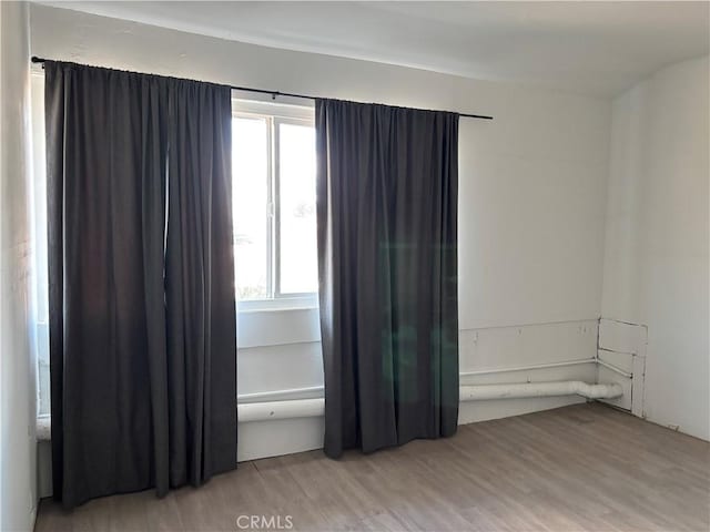 empty room featuring a healthy amount of sunlight and light hardwood / wood-style floors