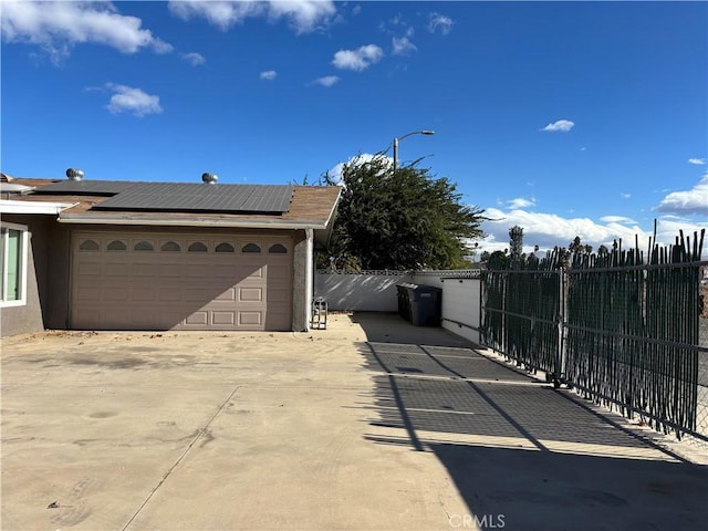 view of side of home featuring solar panels and a garage