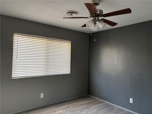 spare room featuring ceiling fan and light hardwood / wood-style flooring