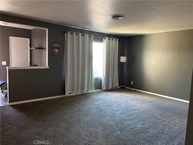 unfurnished room featuring a textured ceiling and carpet flooring