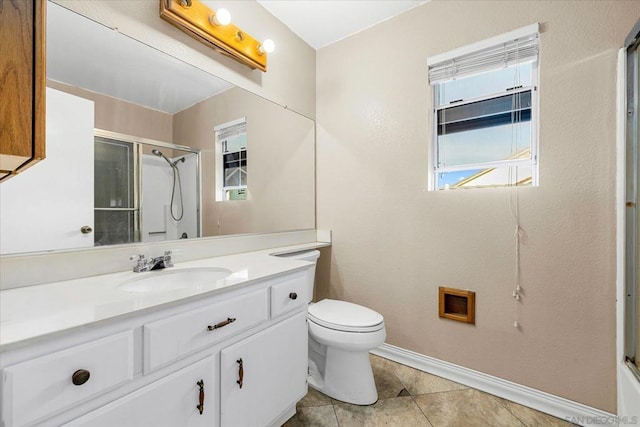 bathroom featuring tile patterned flooring, toilet, a shower with door, and vanity