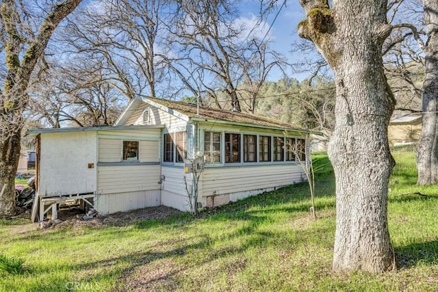 exterior space with a front lawn and a sunroom