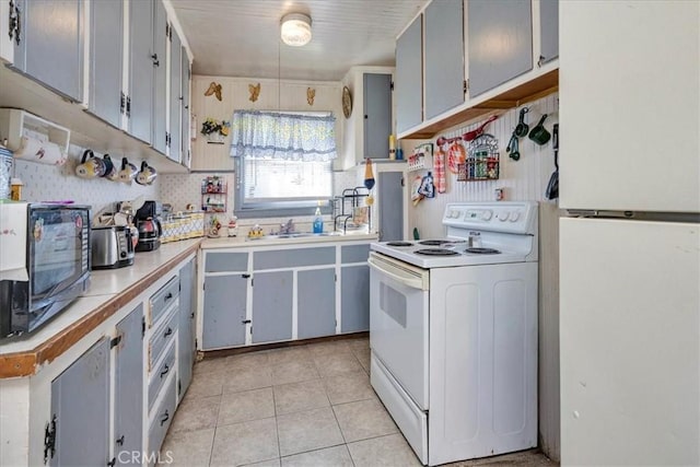 kitchen featuring gray cabinets, light tile patterned floors, sink, and white appliances