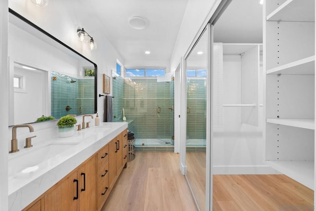 bathroom with wood-type flooring, an enclosed shower, and vanity