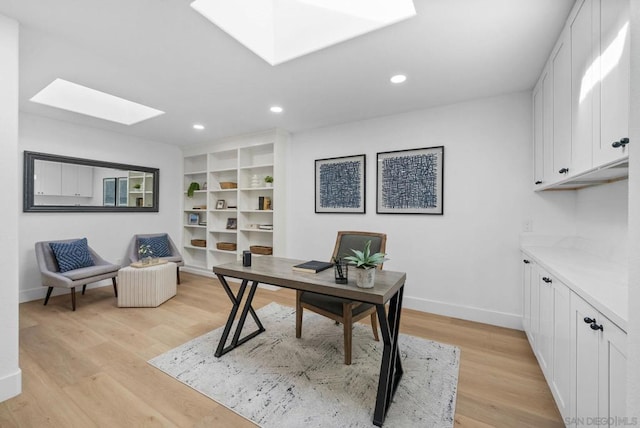 office featuring light hardwood / wood-style flooring and a skylight