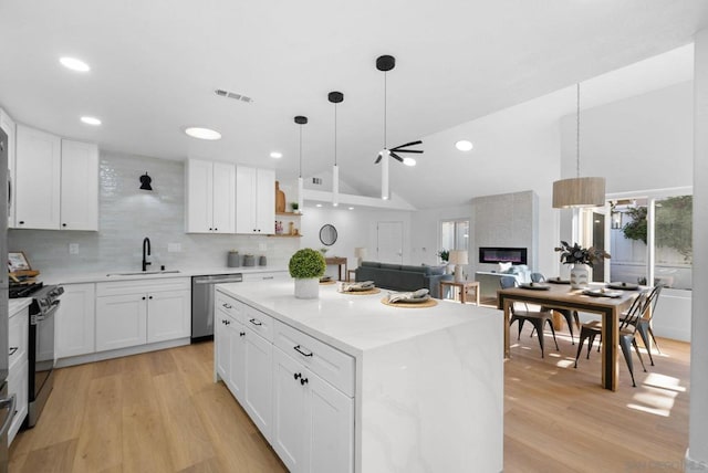 kitchen featuring sink, white cabinetry, a center island, and stainless steel appliances