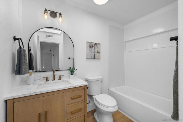 full bathroom featuring shower / bathtub combination, hardwood / wood-style floors, toilet, and vanity