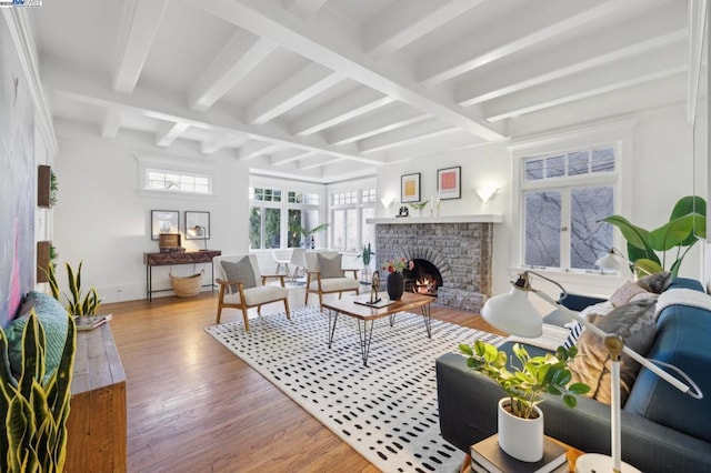 living room with hardwood / wood-style flooring, coffered ceiling, a fireplace, and beamed ceiling