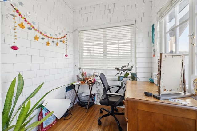 office space with brick wall and hardwood / wood-style floors