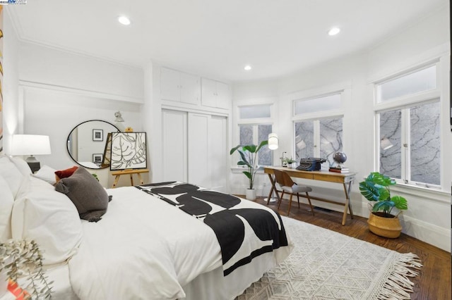 bedroom with dark wood-type flooring and a closet