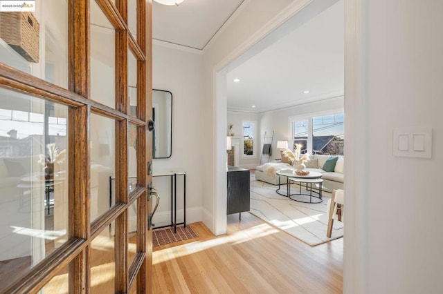 corridor with hardwood / wood-style floors and ornamental molding