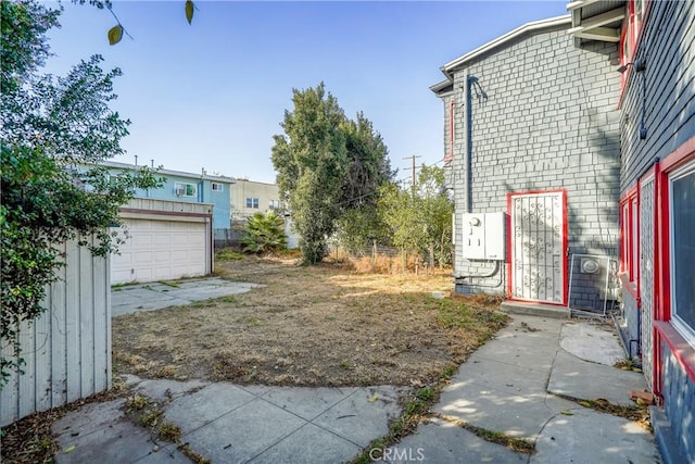 view of yard with a garage and an outbuilding