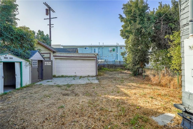 view of yard featuring a garage and an outbuilding