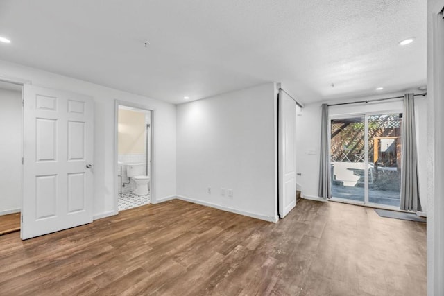 spare room with a textured ceiling and hardwood / wood-style floors