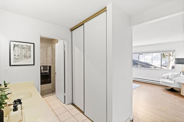 bathroom featuring vanity, hardwood / wood-style flooring, and baseboard heating