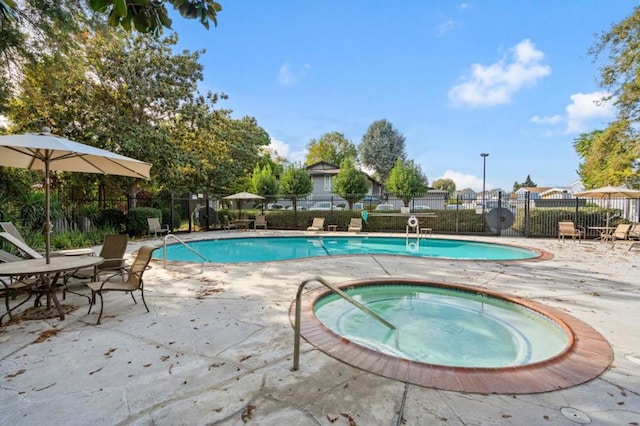 view of swimming pool featuring a community hot tub and a patio