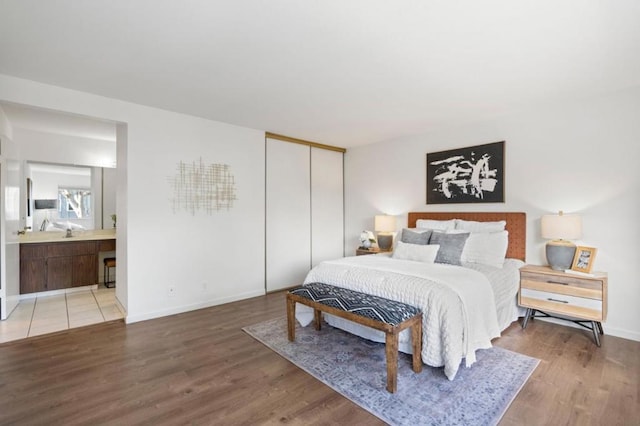 bedroom featuring ensuite bath, hardwood / wood-style floors, and a closet