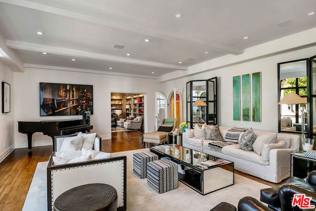 living room featuring light wood-type flooring, a healthy amount of sunlight, and beam ceiling