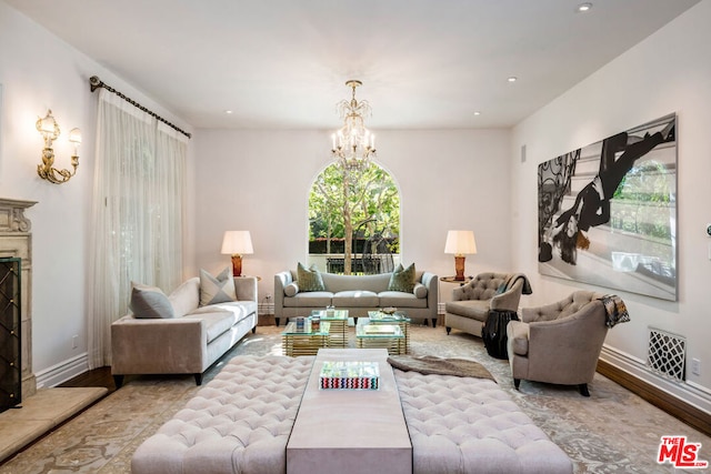 living room featuring light hardwood / wood-style floors, a premium fireplace, and a notable chandelier