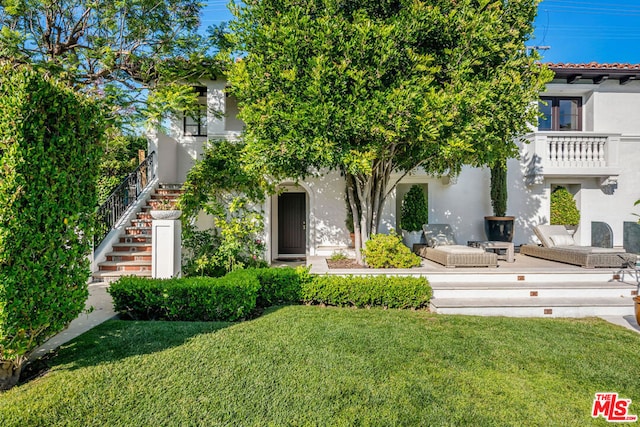 view of front of house featuring a patio area and a front yard