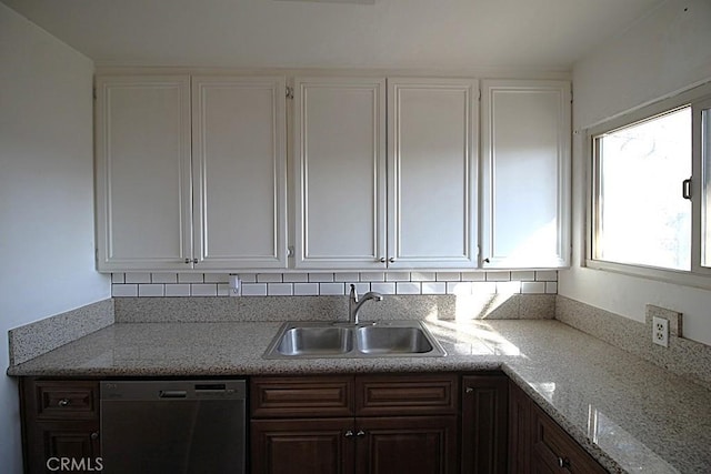 kitchen with dark brown cabinetry, black dishwasher, sink, and white cabinets