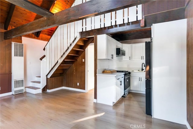 kitchen featuring appliances with stainless steel finishes, white cabinetry, high vaulted ceiling, wooden ceiling, and beam ceiling