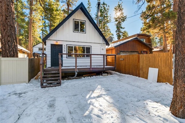 snow covered house with a wooden deck