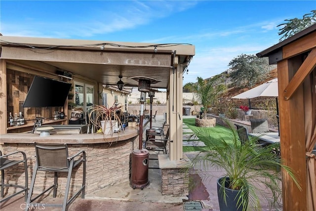 view of patio / terrace with ceiling fan and an outdoor bar